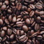 A detailed view of aromatic roasted Arabica coffee beans, highlighting texture and brown color.